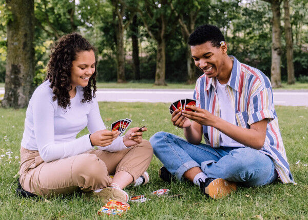 man-and-woman-sitting-on-grass-playing-cards-2981571